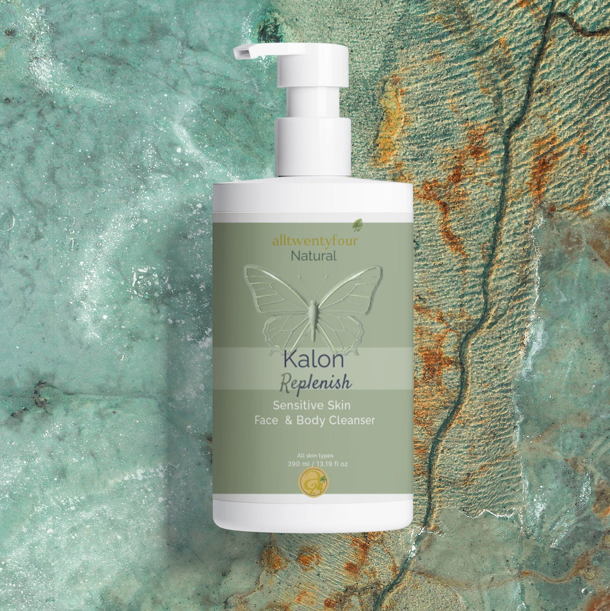 A bottle of Kalon Natural Sensitive Skin Face & Body Cleanser with a white pump and a sage green label, set against a textured turquoise and brown stone background.